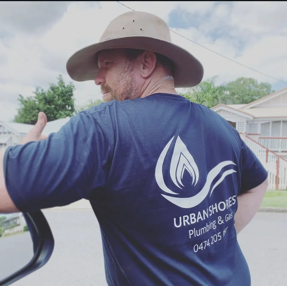 Urban Shores team member in branded workwear outside a residential property.
